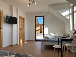 a bedroom with a bed and a dining room with a table at Noclegi Widokowa Przystań in Krajno Pierwsze