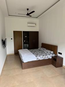 a bedroom with a bed and a ceiling fan at Bhoomi in Mysore