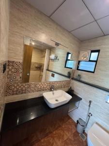 a bathroom with a sink and a mirror at Bhoomi in Mysore