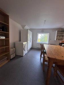 a dining room with a table and a refrigerator at Workers Stay - Worker Accommodation Torslanda - Volvo - Sweden in Gothenburg