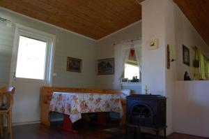 a living room with a table and a stove at Guesthouse in Hellosan in Vestvågøya