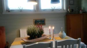 a table with two candles and a potted plant on it at Guesthouse in Hellosan in Vestvågøya +10 photos
