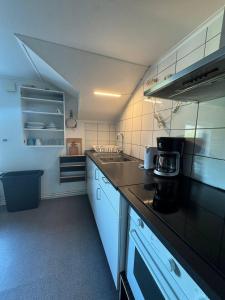 a kitchen with a black counter top and white appliances at Workers Stay - Worker Accommodation Torslanda - Volvo - Sweden in Gothenburg