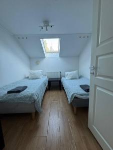 a attic room with two beds and a window at Workers Stay - Worker Accommodation Torslanda - Volvo - Sweden in Gothenburg