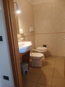 a bathroom with a toilet and a sink at Hotel Ponsacco HP in Ponsacco