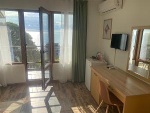 a room with a desk and a television and a balcony at Only Adults- RAI in Golden Sands