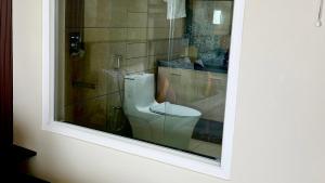 a bathroom with a toilet through a window at Clouds end Resorts Munnar in Jāmb +20 photos