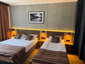 two beds in a hotel room with two beds at Hotel Martex in Płońsk
