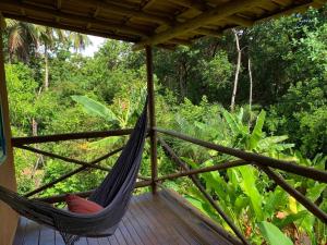 a hammock on a porch with a view of a forest at Casa da Roça- Casa completa e jardim privativo in Mata de Sao Joao