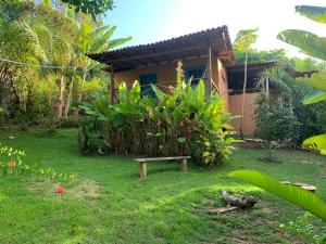a garden with a bench in front of a house at Casa da Roça- Casa completa e jardim privativo in Mata de Sao Joao +21 photos