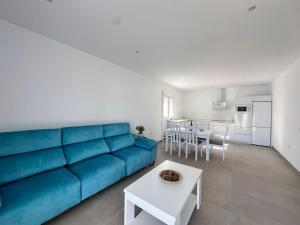 a living room with a blue couch and a table at Chalet Chiclana in Chiclana de la Frontera