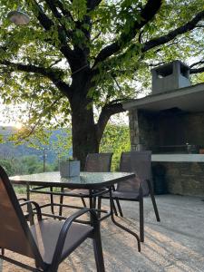 a table and chairs sitting under a tree at SO SIMPLE mouresi in Mouresi +10 photos