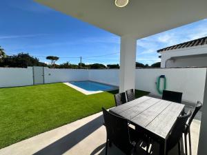 a patio with a table and chairs and a pool at Chalet Chiclana in Chiclana de la Frontera