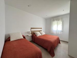 a bedroom with two beds and a window at Chalet Chiclana in Chiclana de la Frontera +28 photos