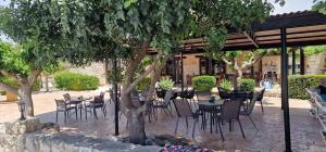 a patio with tables and chairs under a tree at Drouseia Karithea House in Drousha