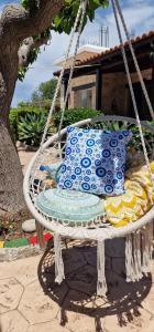 a swing with blue and white pillows on it at Drouseia Karithea House in Drousha