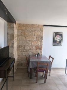 a dining room with a table and a brick wall at Drouseia Karithea House in Drousha +6 photos