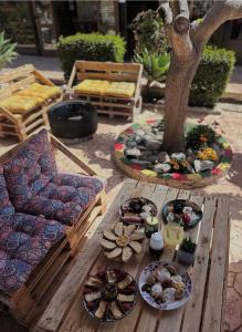 a table with plates of food on it next to a tree at Drouseia Karithea House in Drousha