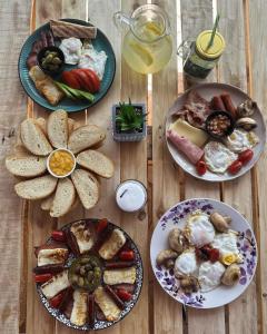 a wooden table with plates of breakfast food on it at Drouseia Karithea House in Drousha