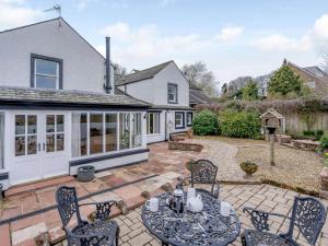 a patio with a table and chairs in front of a house at 4 Bed in Wigton oc-79563 in Calvo