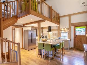 a kitchen with a table with green chairs and a staircase at 3 Bed in Worcester oc-41983 in Broadwas