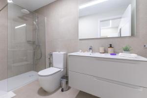 a bathroom with a toilet and a sink and a shower at Brisamar Suites I by VillaGranCanaria in Arinaga +42 photos