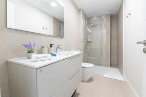 a white bathroom with a sink and a shower at Brisamar Suites I by VillaGranCanaria in Arinaga