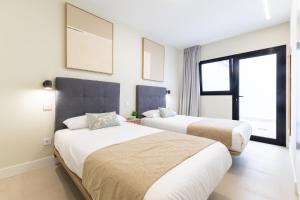 a hotel room with two beds and a window at Brisamar Suites I by VillaGranCanaria in Arinaga
