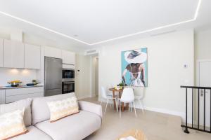 a living room and kitchen with a couch and a table at Brisamar Suites I by VillaGranCanaria in Arinaga