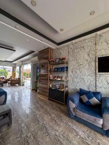a living room with a blue couch and a tv at 4S Hotel Dahab in Dahab