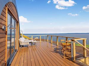a wooden deck with a table and chairs on the water at 1 Bed in Tain oc-96065 in Nigg