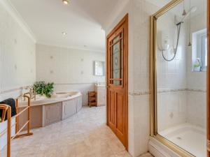 a bathroom with a tub and a sink and a shower at 6 Bed in Tenby oc-fb220 in Tenby +21 photos
