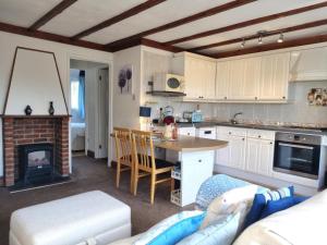 a kitchen with a living room with a fireplace at 2 Bed in Galmpton oc-bx008 in Galmpton-on-the-Dart