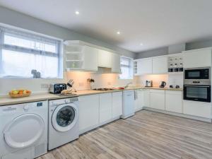 a kitchen with white cabinets and a washer and dryer at 2 Bed in Northwich oc-85877 in Kingsley +13 photos