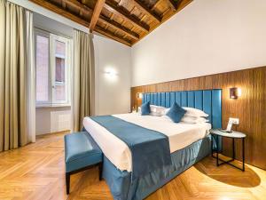 a bedroom with a large bed with a blue headboard at Albergo Abruzzi in Rome
