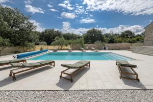 a swimming pool with chaise lounge chairs and a swimming pool at Demare in Gospić