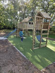 a young boy playing on a playground with a slide at La Champagnère - Domaine avec piscine - Séminaire - 15 personnes in Basse-Goulaine