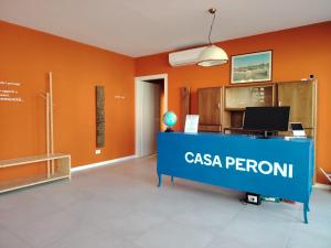 an office with a casa peruvian sign on a desk at Ostello Casa Peroni in Castelnuovo Bocca dʼAdda