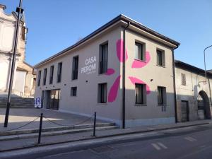 a building with pink paint on the side of it at Ostello Casa Peroni in Castelnuovo Bocca dʼAdda