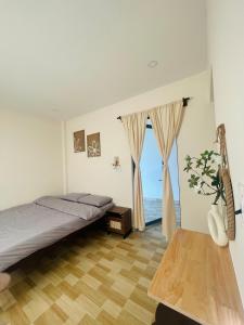 a bedroom with a bed and a large window at Homestay 234 Dốc Lết in Ba Ha