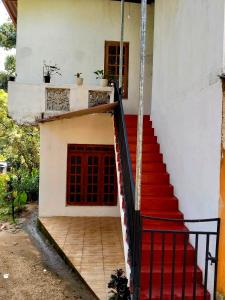 a staircase leading up to a house with a red door at Ramanayaka Serenity Villa in Bandarawela