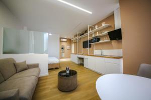 a large living room with a couch and a kitchen at Denis Studios Durres in Durrës