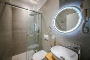 a bathroom with a shower and a sink and a mirror at Denis Studios Durres in Durrës +13 photos