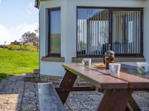 a wooden picnic table in front of a house at 3 Bed in Berwick-upon-tweed oc-87777 in Lamberton