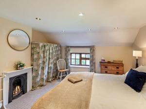 a bedroom with a large bed and a fireplace at 3 Bed in Buckingham oc-94701 in Finmere +27 photos