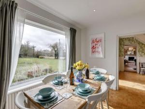 a dining room with a table and a large window at 3 Bed in Malvern oc-90775 in Mathon