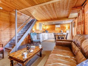 a living room with a couch and a staircase in a cabin at 1 Bed in Gairloch oc-ca044 in Gairloch