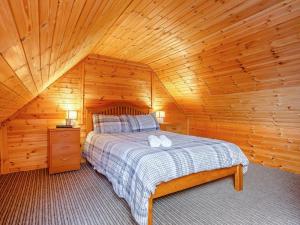 a bedroom with a bed in a wooden cabin at 1 Bed in Gairloch oc-ca044 in Gairloch