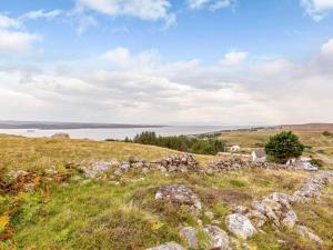 a grassy hill with a house on top of it at 1 Bed in Gairloch oc-ca044 in Gairloch +9 photos