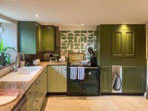 a kitchen with green cabinets and a green refrigerator at 2 Bed in Chipping Norton oc-73904 in Swerford